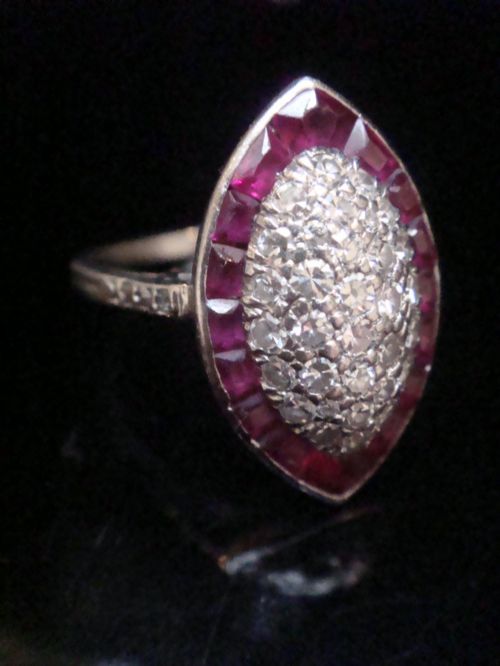 fig 2. An Art Deco marquise cluster ring featuring a central diamond pave setting surrounded by a border of calibre-cut red rubies.