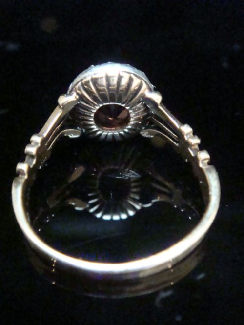fig 1. An Edwardian 18ct gold ring with a central cushion-cut peach tourmaline surrounded by a halo of old-cut diamonds and bifurcated shoulders.