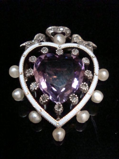 fig 1. An Edwardian heart-shaped gold pendant featuring a central purple gemstone framed by diamonds, white guilloche enamel, and small natural pearls.