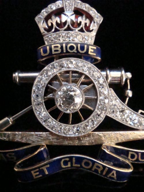 fig 1. An Edwardian platinum and gold Royal Artillery badge brooch featuring blue guilloche enamel mottos and diamond settings.