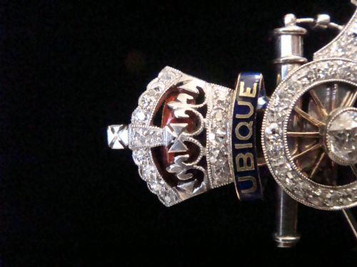 fig 2. An Edwardian platinum and gold Royal Artillery badge brooch featuring blue guilloche enamel mottos and diamond settings.