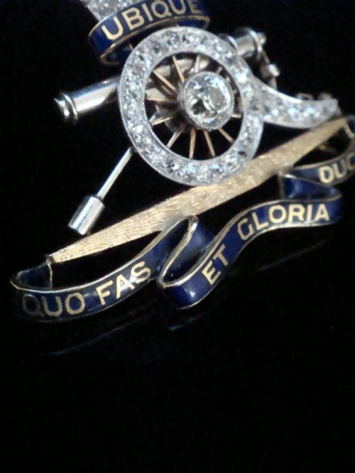 fig 4. An Edwardian platinum and gold Royal Artillery badge brooch featuring blue guilloche enamel mottos and diamond settings.