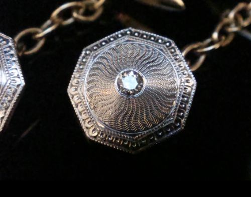A pair of Edwardian cufflinks featuring octagonal platinum faces with engine-turned sunburst detailing and central old-cut diamonds, connected by chains to yellow gold torpedo backs. View III