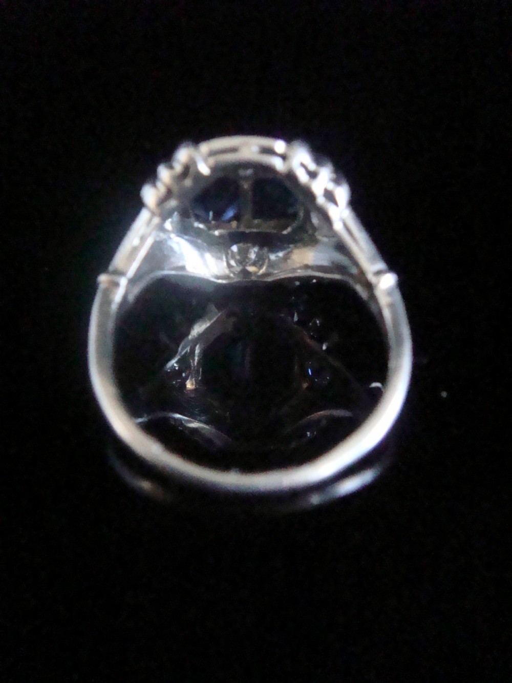 An Art Deco platinum ring featuring two central rectangular blue sapphires flanked by round diamonds and detailed milgrain edging. View III