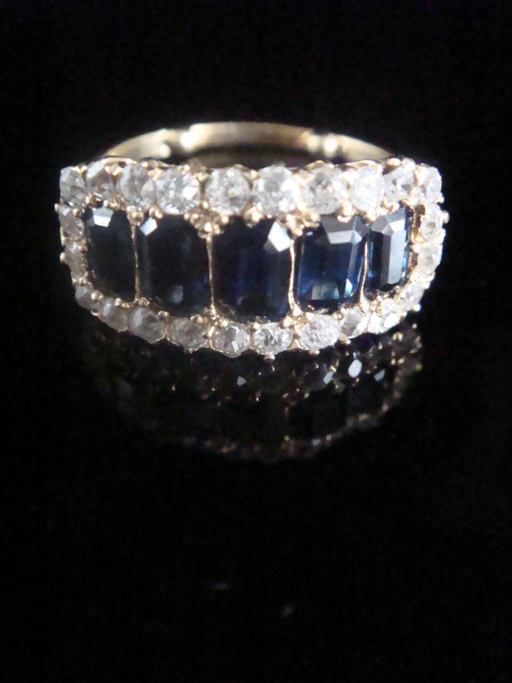 An 18ct yellow gold Victorian boat ring featuring central sapphires framed by a border of small round diamonds. View III