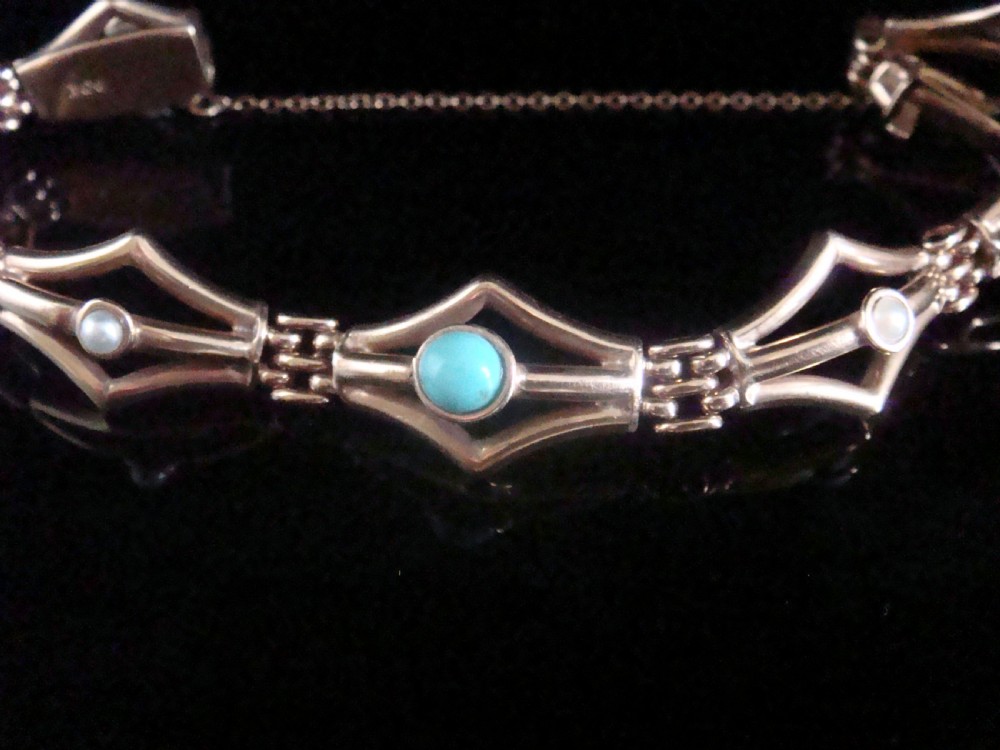 A Victorian 9ct gold link bracelet featuring openwork diamond-shaped motifs set with central turquoise cabochons and pearls.