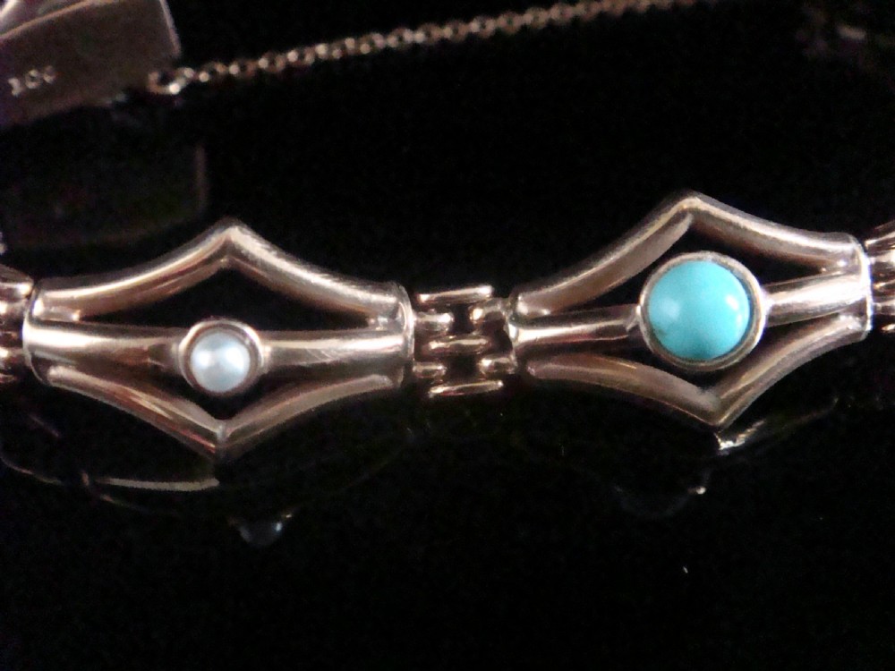 A Victorian 9ct gold link bracelet featuring openwork diamond-shaped motifs set with central turquoise cabochons and pearls. View II