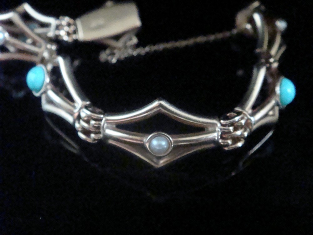 A Victorian 9ct gold link bracelet featuring openwork diamond-shaped motifs set with central turquoise cabochons and pearls. View IV