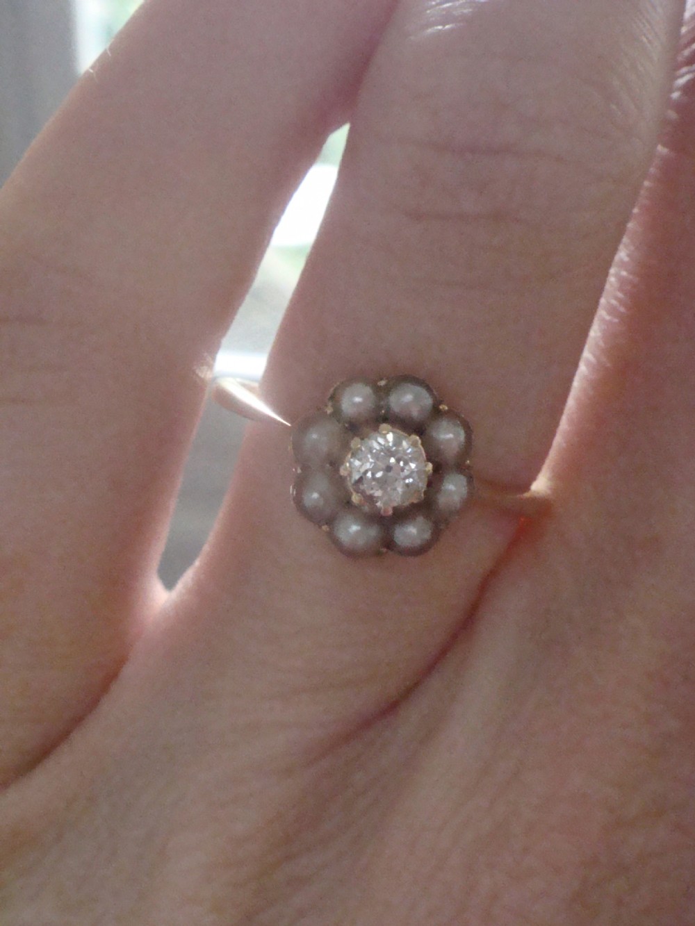 An Edwardian 18ct yellow gold cluster ring featuring a central old cut diamond surrounded by eight small pearls. View II