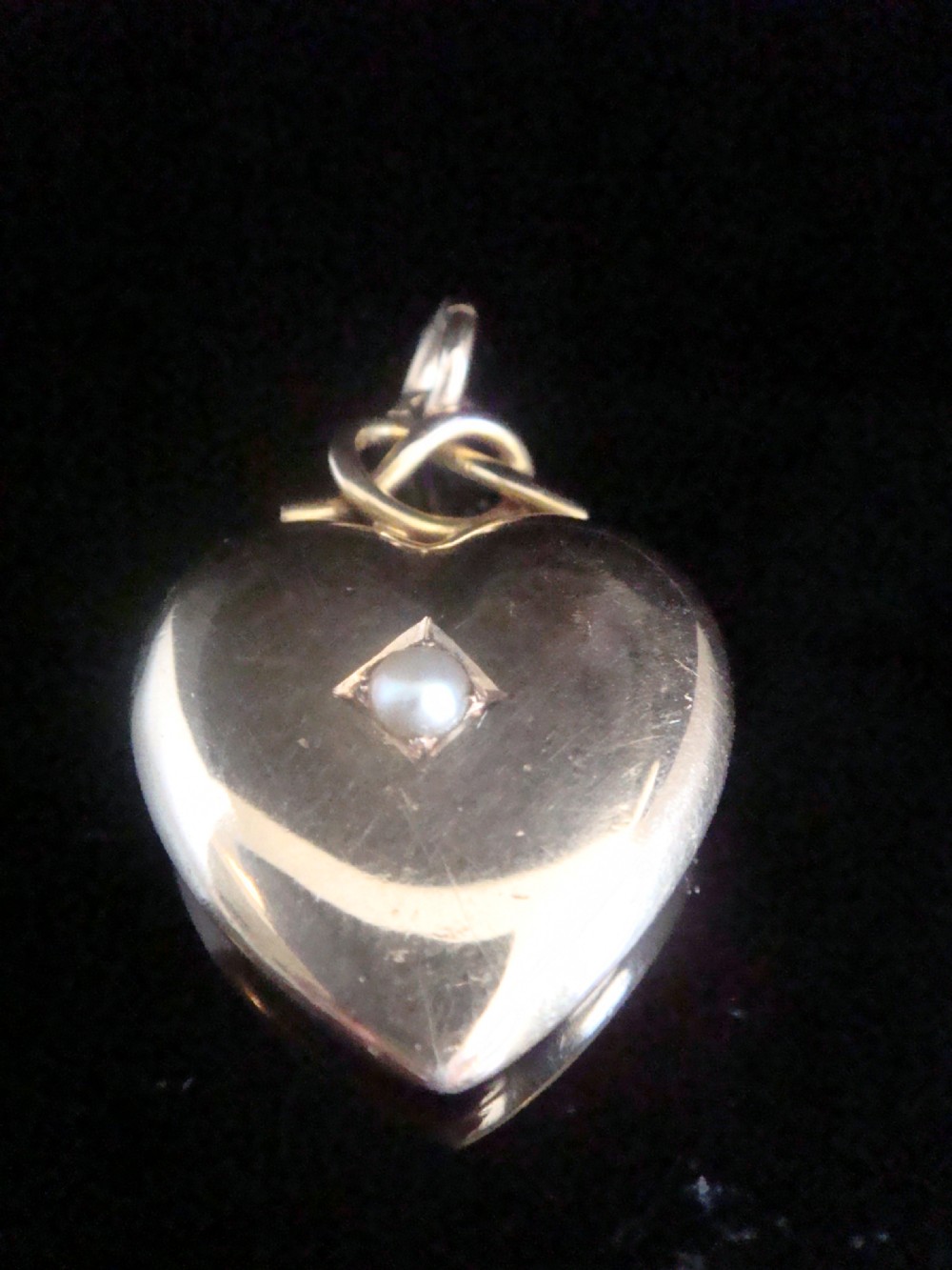 A Victorian 15ct yellow gold puffed heart pendant set with a central seed pearl in a diamond-shaped star setting. View III