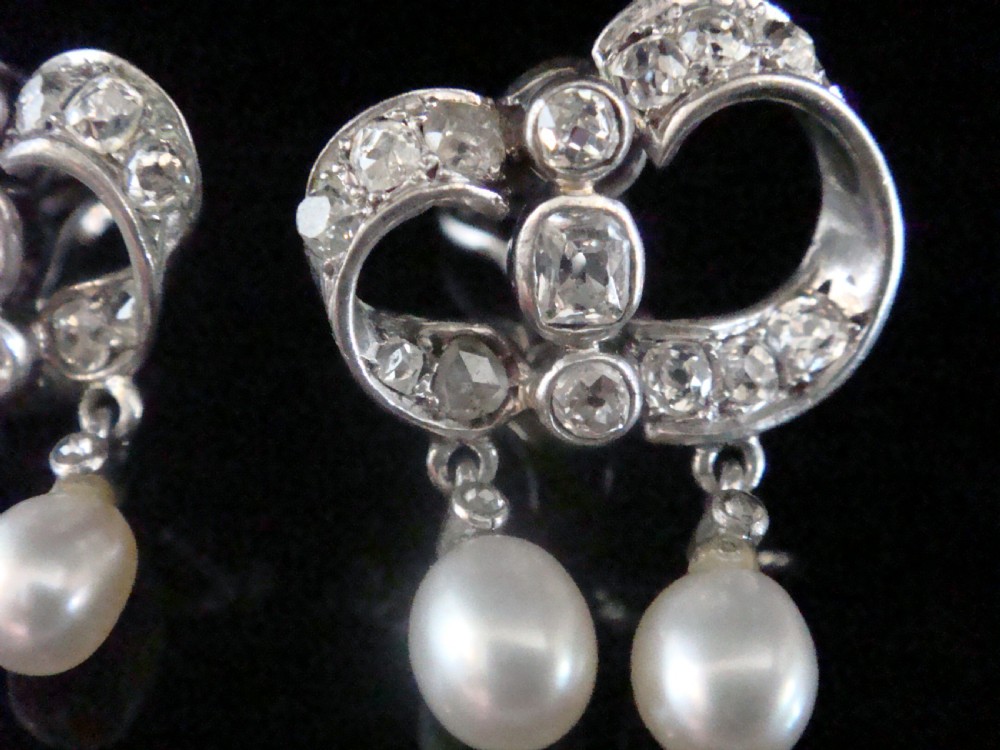 A pair of antique silver bow motif drop earrings set with old-cut diamonds and natural pearl drops. View VI
