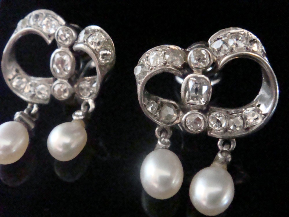 A pair of antique silver bow motif drop earrings set with old-cut diamonds and natural pearl drops. View II