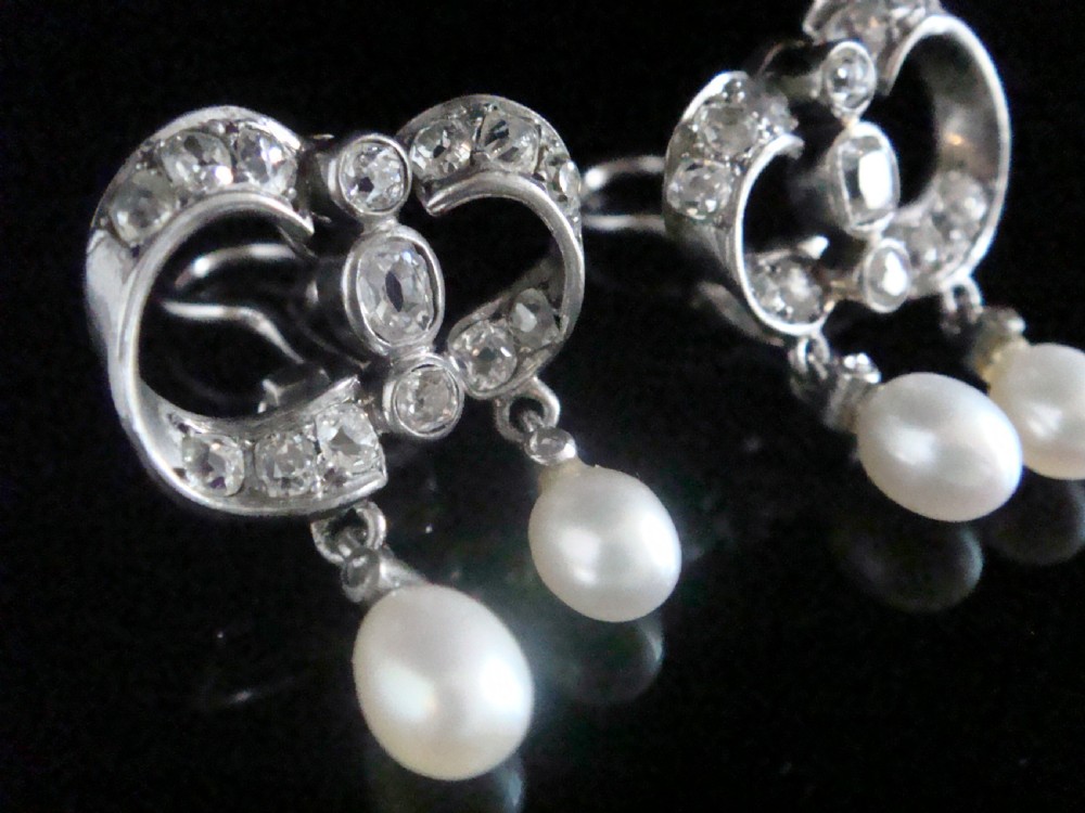 A pair of antique silver bow motif drop earrings set with old-cut diamonds and natural pearl drops. View III