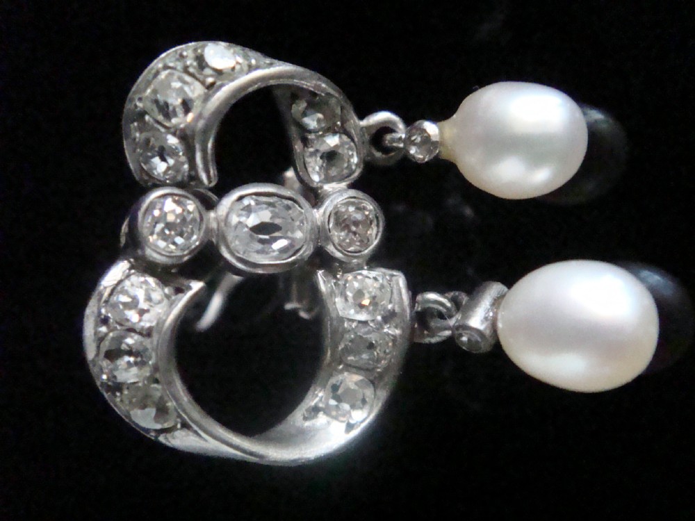 A pair of antique silver bow motif drop earrings set with old-cut diamonds and natural pearl drops. View IV