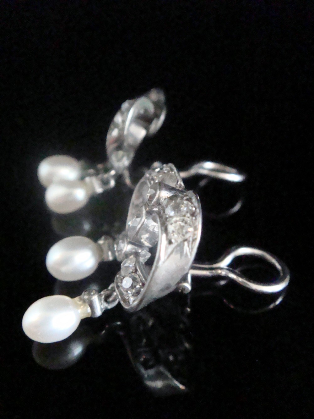 A pair of antique silver bow motif drop earrings set with old-cut diamonds and natural pearl drops. View VII