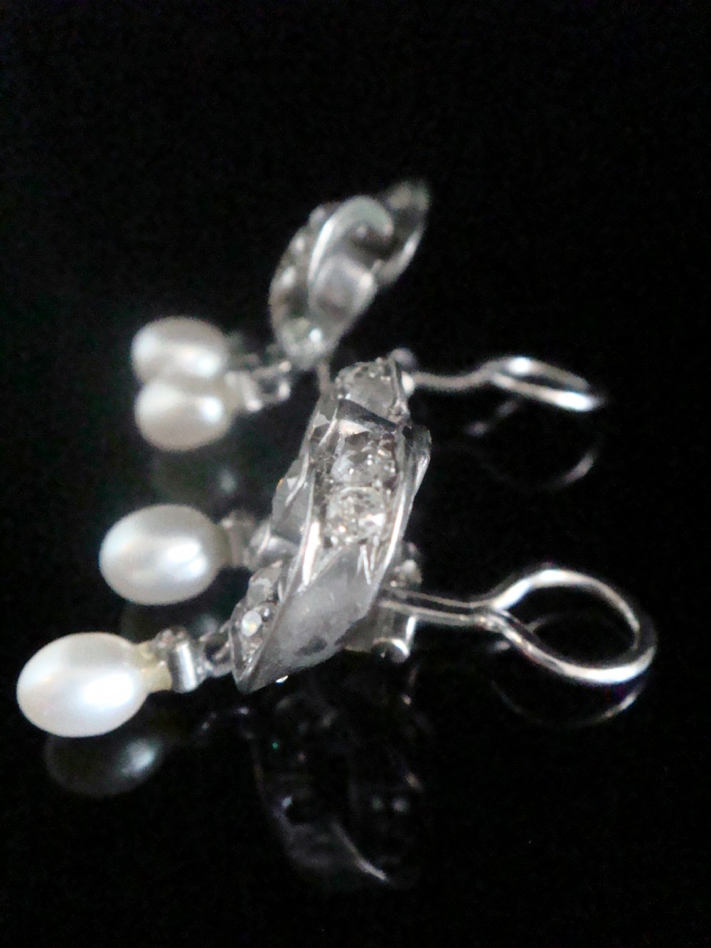 A pair of antique silver bow motif drop earrings set with old-cut diamonds and natural pearl drops. View VIII