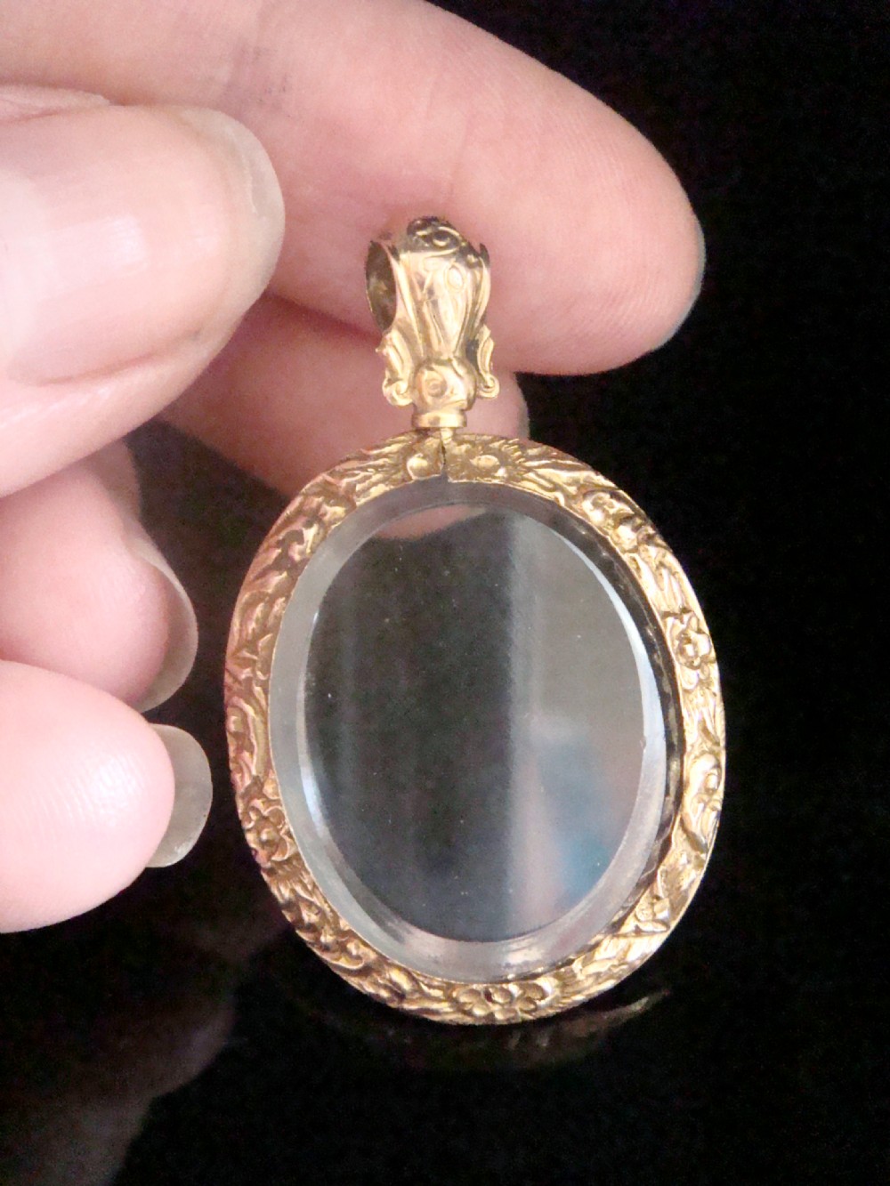 An oval Victorian 9ct yellow gold picture locket featuring engraved foliate patterns around bevelled glass covers. View III