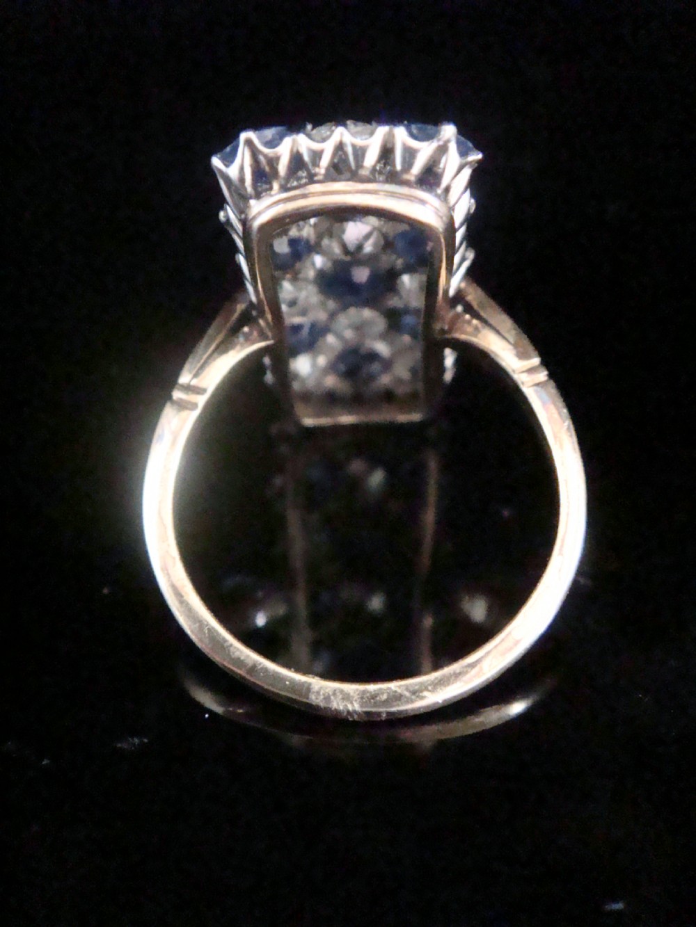 An Art Deco rectangular plaque dress ring featuring a grid setting of round blue sapphires and old cut diamonds set in platinum atop a gold band. View IV