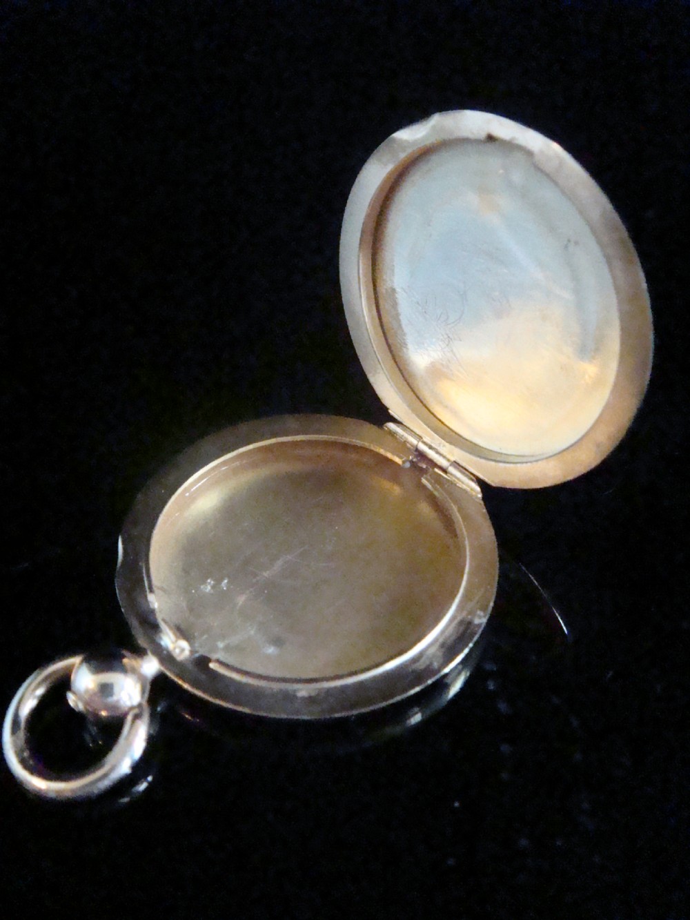 A round Victorian 15ct yellow gold locket shaped like a pocket watch with a top loop and glass compartment. View II