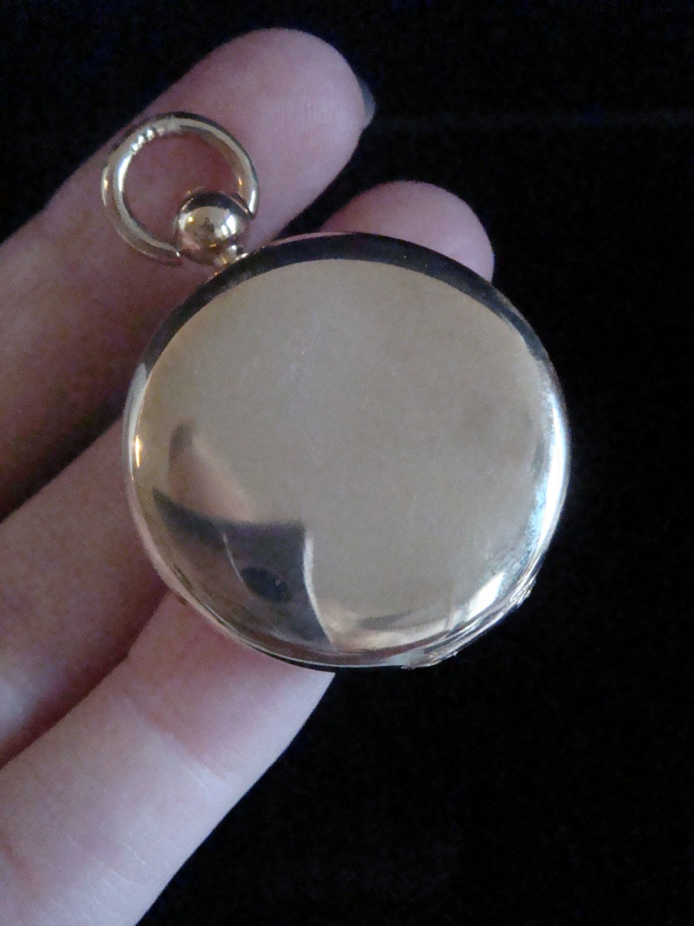 A round Victorian 15ct yellow gold locket shaped like a pocket watch with a top loop and glass compartment. View III