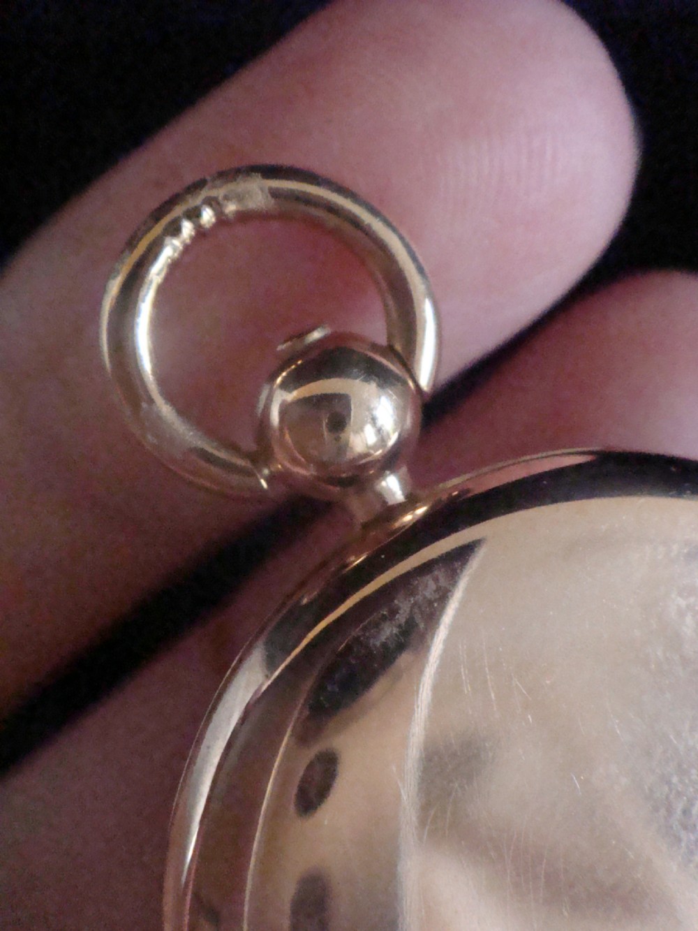 A round Victorian 15ct yellow gold locket shaped like a pocket watch with a top loop and glass compartment. View IV