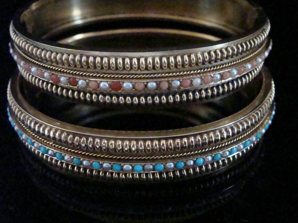 A pair of Victorian 15ct gold bangles featuring beaded borders and central rows of alternating seed pearls, coral, and turquoise cabochons. View V