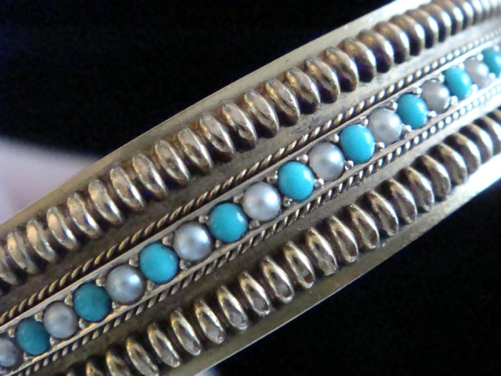 A pair of Victorian 15ct gold bangles featuring beaded borders and central rows of alternating seed pearls, coral, and turquoise cabochons. View VII