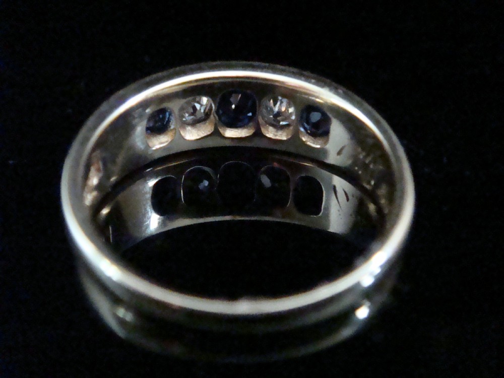 A Victorian 18ct yellow gold gypsy ring set with five alternating blue sapphires and old cut diamonds flush inside a wide band. View II