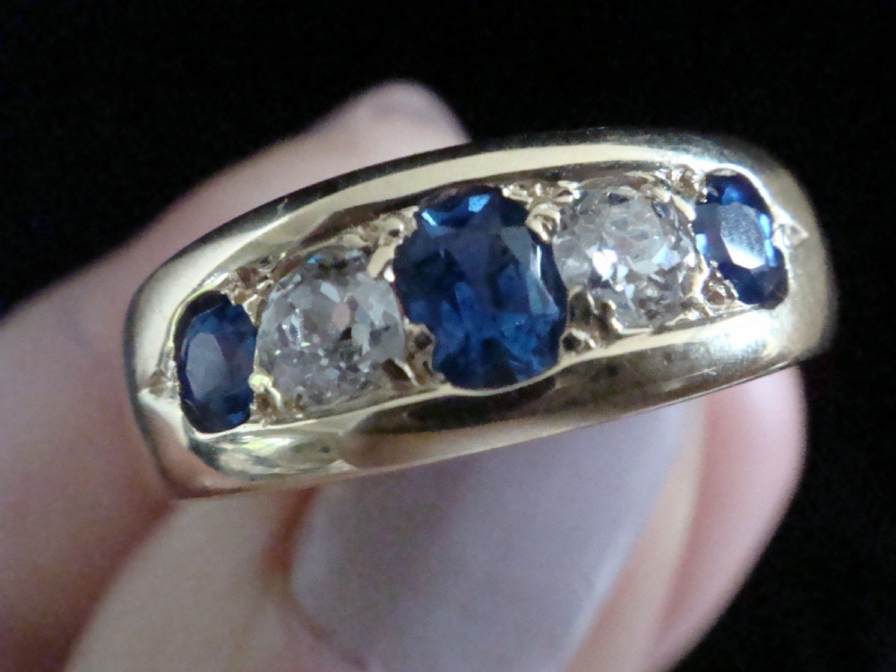A Victorian 18ct yellow gold gypsy ring set with five alternating blue sapphires and old cut diamonds flush inside a wide band. View IV