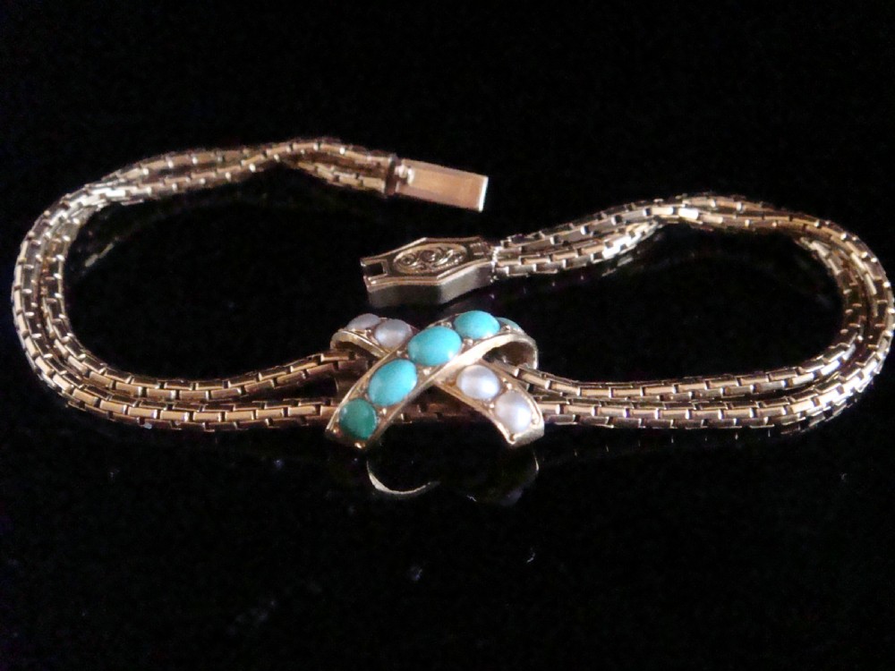 A Victorian 15ct rose gold double snake chain bracelet featuring a central lovers knot set with turquoise cabochons and pearls.