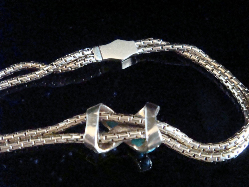 A Victorian 15ct rose gold double snake chain bracelet featuring a central lovers knot set with turquoise cabochons and pearls. View V