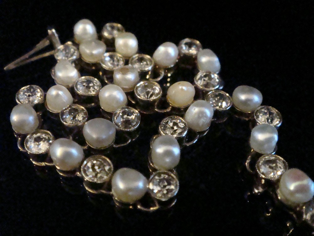 An antique French Edwardian 18ct white gold line bracelet featuring an alternating sequence of natural saltwater pearls and circular-cut diamonds.