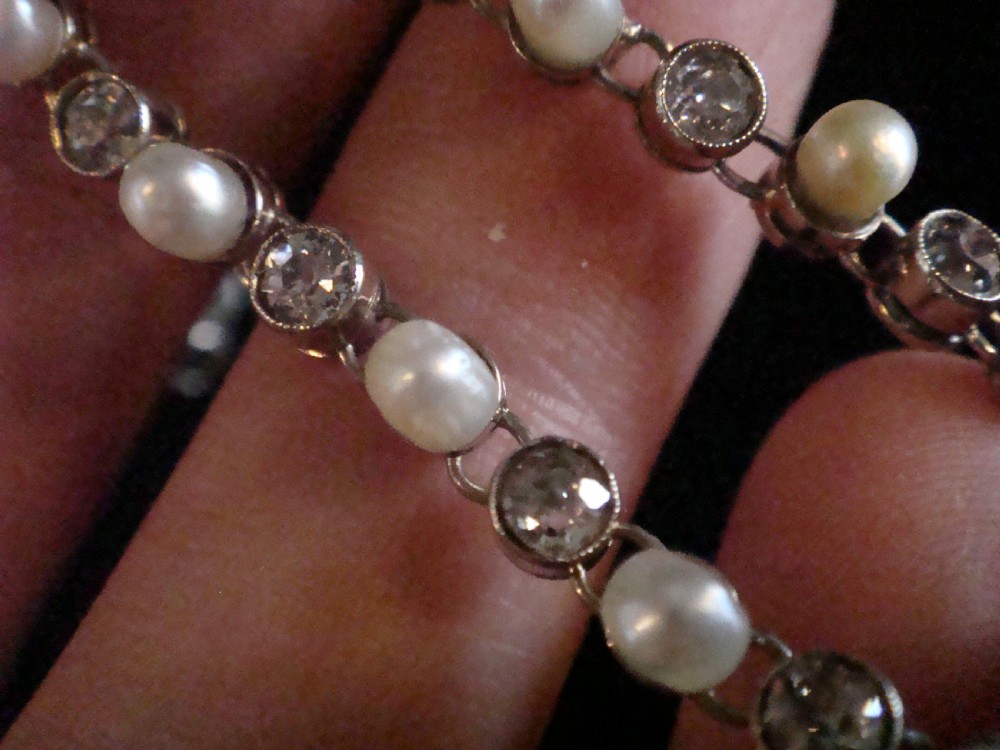 An antique French Edwardian 18ct white gold line bracelet featuring an alternating sequence of natural saltwater pearls and circular-cut diamonds. View IV
