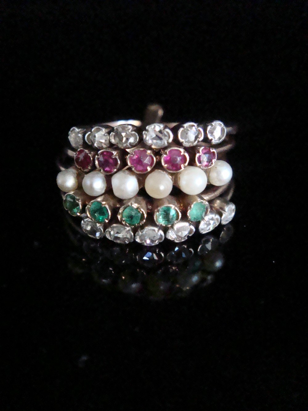 An Edwardian multi-band 18ct rose gold harem ring set with individual rows of diamonds, rubies, seed pearls, and emeralds. View III
