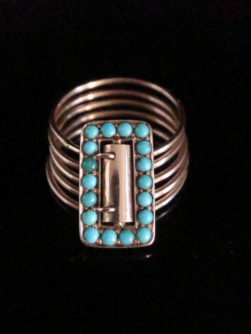A Victorian 18ct rose gold five-row harem ring featuring a central rectangular buckle motif set with circular turquoise cabochons.
