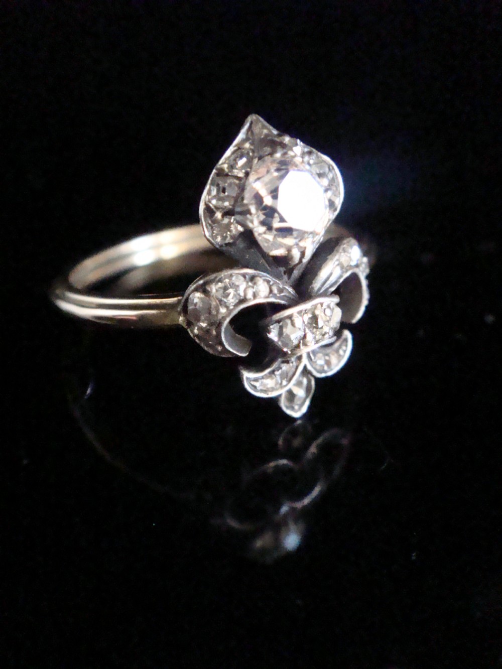 A Georgian silver and gold ring featuring a central fleur-de-lis motif set with old cut diamonds. View II