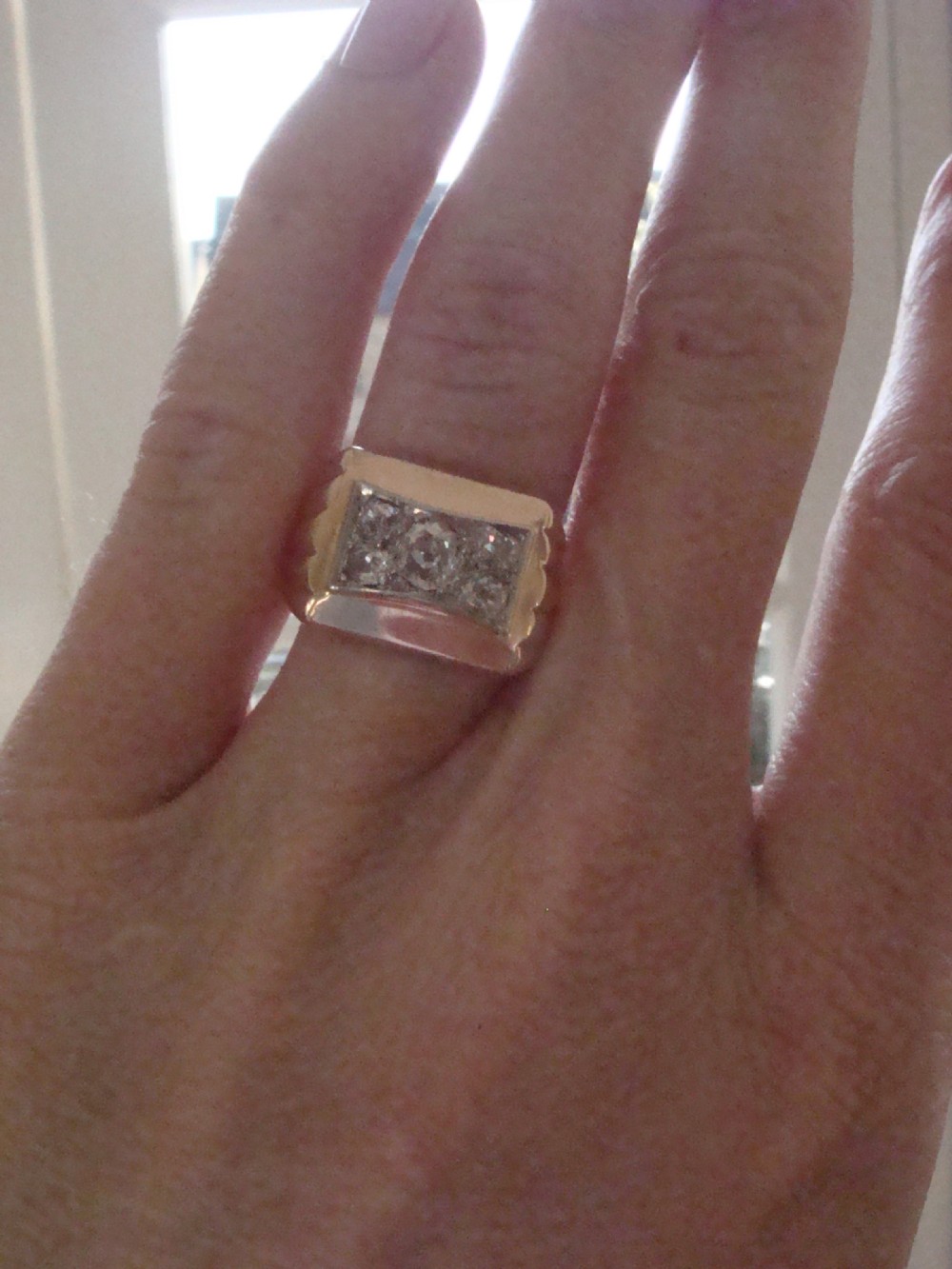 An 18ct yellow gold tank ring featuring a rectangular platinum panel set with bright diamonds. View V