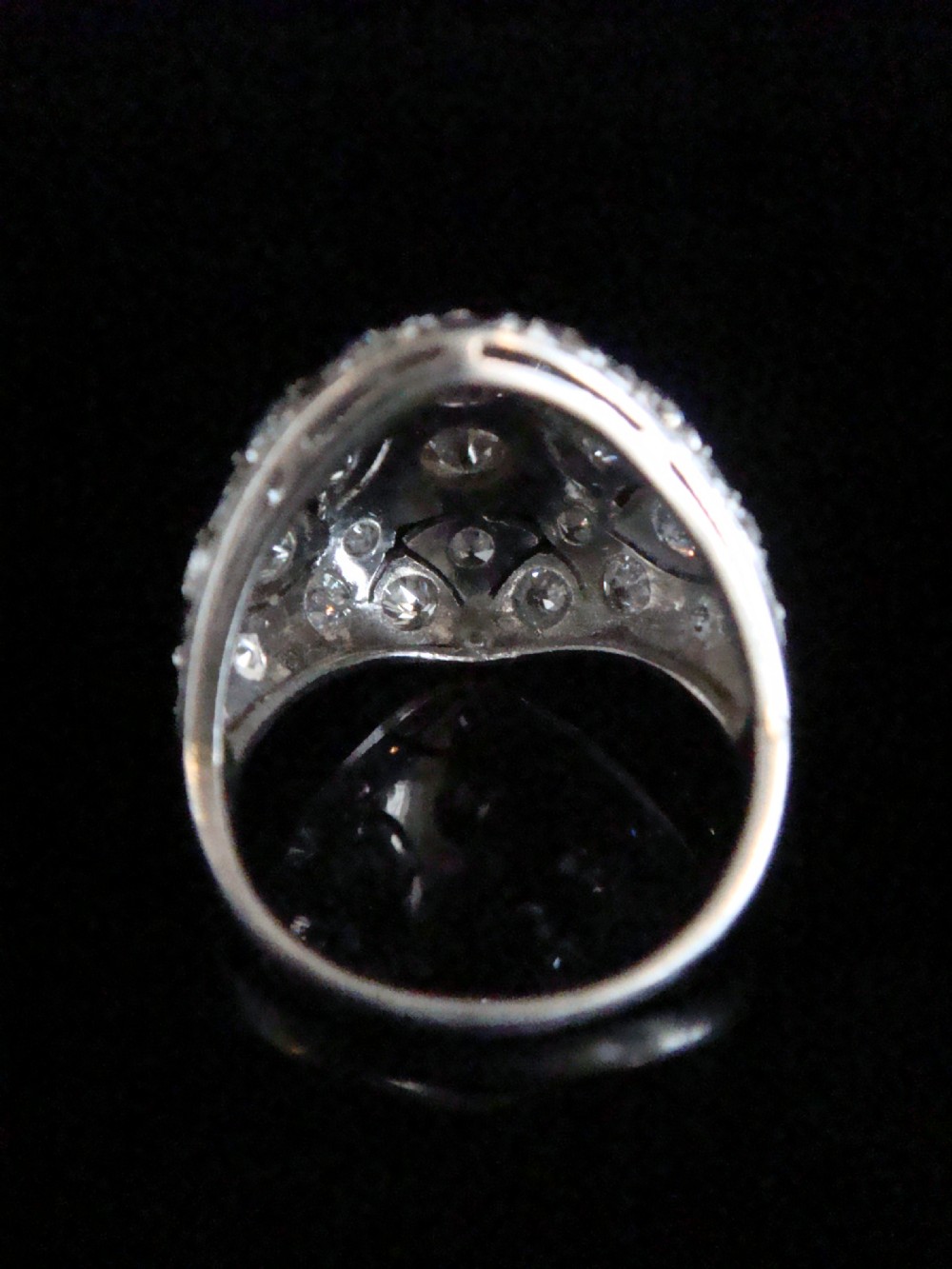 An Art Deco platinum bombe ring set with multiple transitional-cut diamonds in a rounded geometric pattern with millegrain detailing. View II