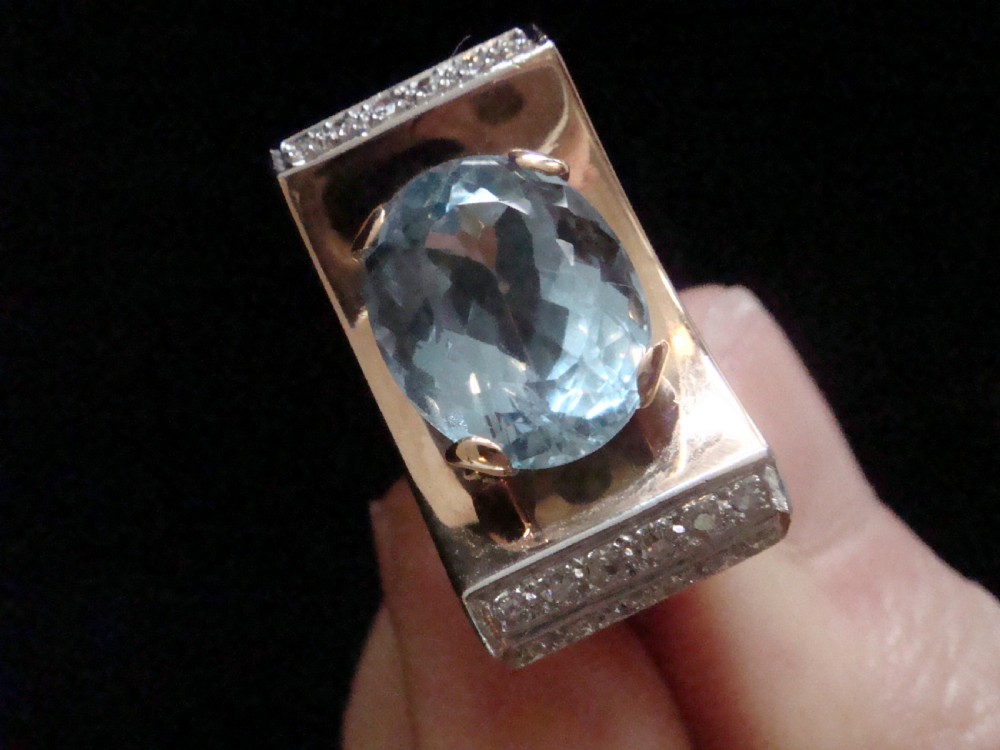 An antique French Tank ring featuring an oval faceted light blue topaz set in gold, framed by broad platinum shoulders set with small accent diamonds. View IV