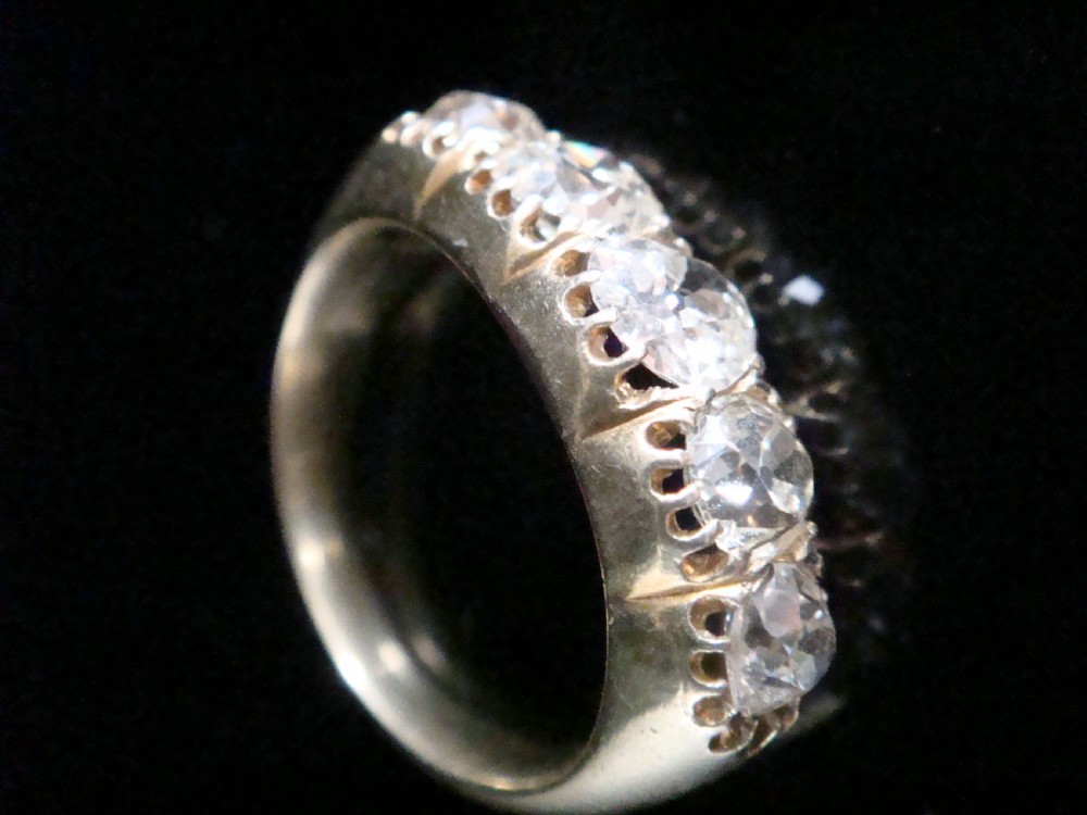 An early Victorian 18ct yellow gold ring featuring five graduated old-cut diamonds set horizontally along a carved gallery. View II