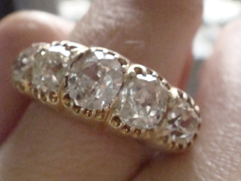 An early Victorian 18ct yellow gold ring featuring five graduated old-cut diamonds set horizontally along a carved gallery. View III