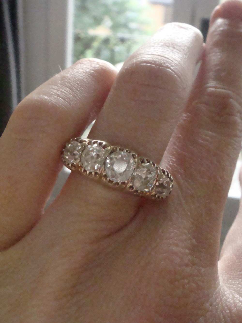 An early Victorian 18ct yellow gold ring featuring five graduated old-cut diamonds set horizontally along a carved gallery. View IV