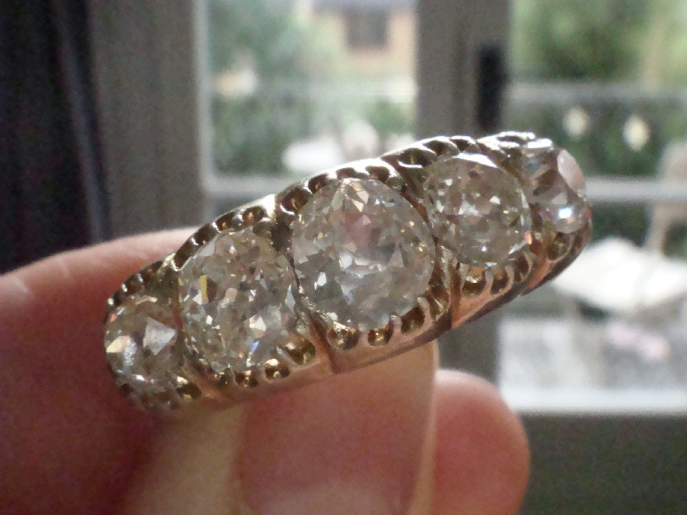 An early Victorian 18ct yellow gold ring featuring five graduated old-cut diamonds set horizontally along a carved gallery. View V