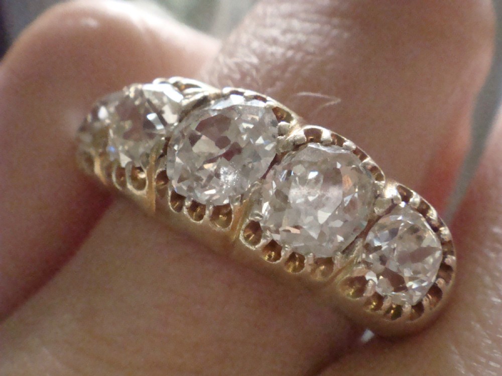 An early Victorian 18ct yellow gold ring featuring five graduated old-cut diamonds set horizontally along a carved gallery. View XIII