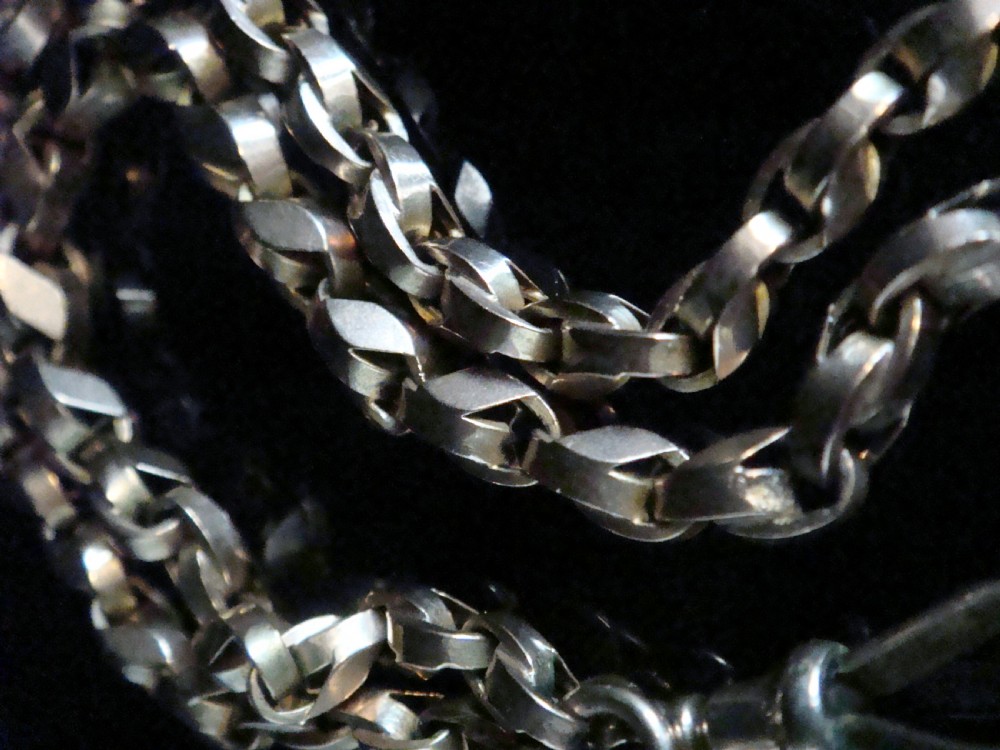 An Edwardian 9ct rose gold Albert chain featuring fancy interlocking links, dual dog clips, and a T-bar attachment. View IV