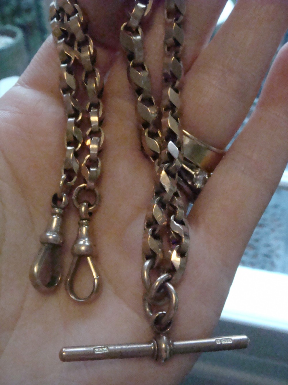 An Edwardian 9ct rose gold Albert chain featuring fancy interlocking links, dual dog clips, and a T-bar attachment. View V