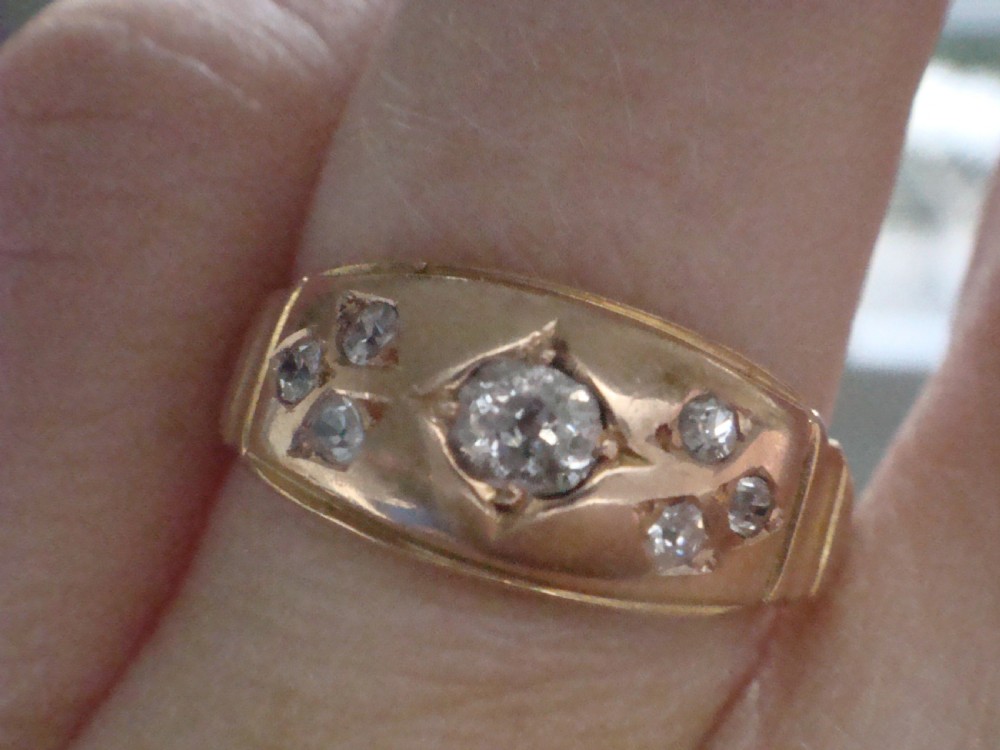 A Victorian 18ct yellow gold band featuring a central old cut diamond flanked by smaller flush-set diamonds in star-engraved settings. View III