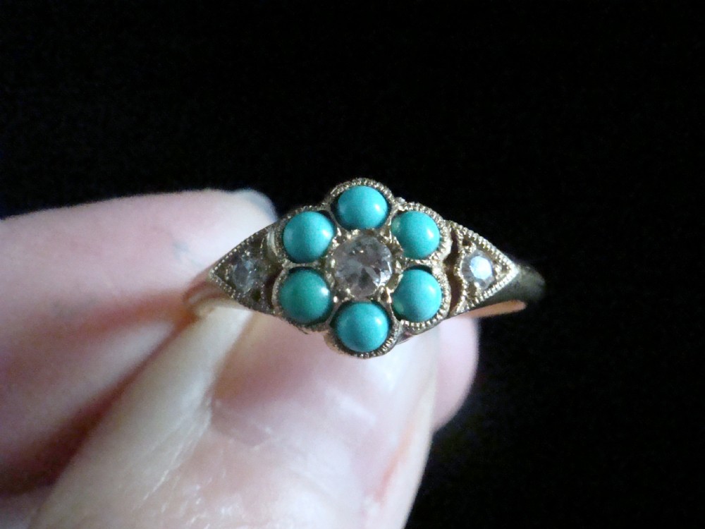 A Victorian 18ct yellow gold cluster ring featuring a central diamond surrounded by six turquoise cabochons with milgrain-detailed shoulders. View IV