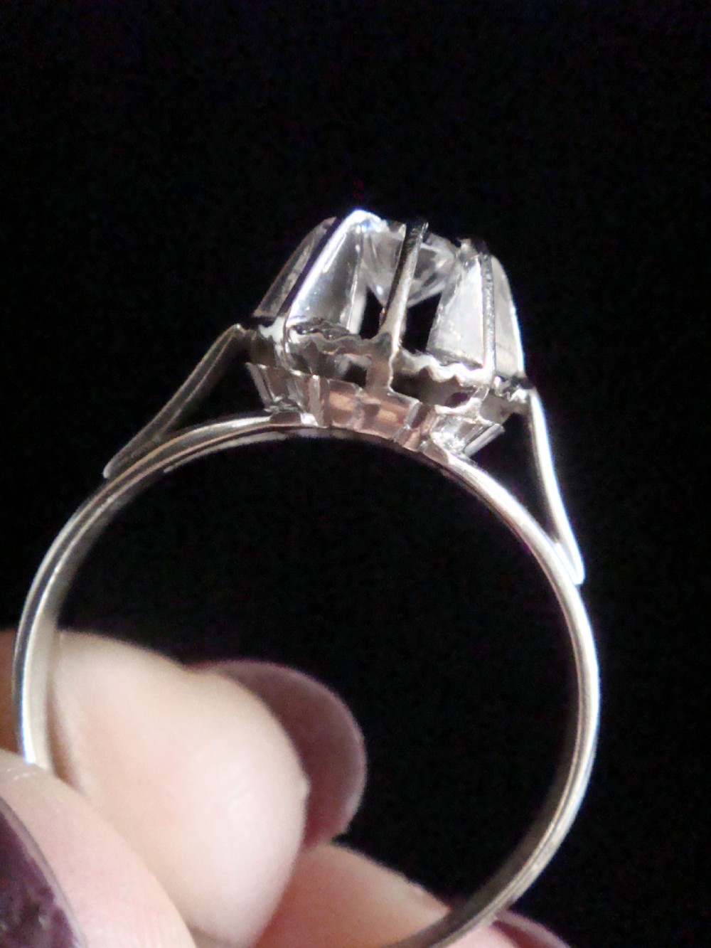 A vintage 18ct white gold solitaire ring featuring a central round diamond set within a fluted sunburst surround. View III