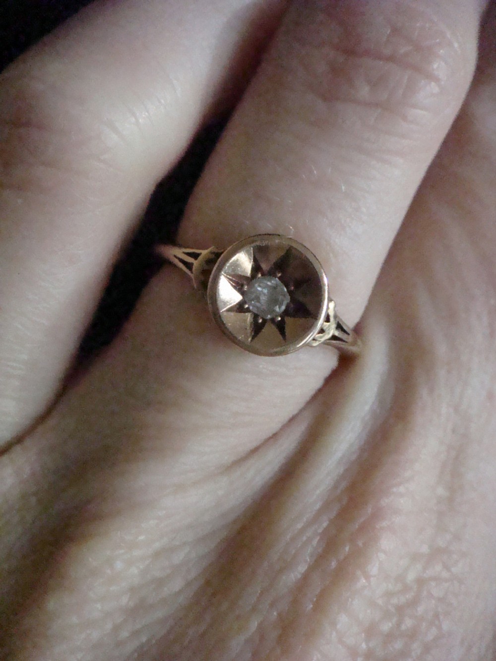An 18ct yellow gold Victorian ring featuring a central starburst engraving with a single flush-set diamond. View IV